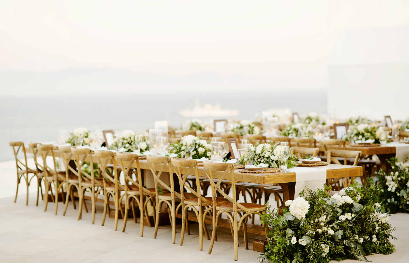 Scenic Mykonos wedding reception with stunning white and green floral arrangements, Mykonos wedding dinner set up and design